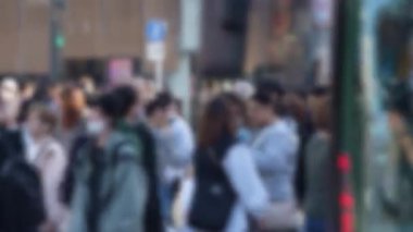 Japonya 'daki ünlü Shibuya Geçidi' ndeki kalabalık kalabalığın yoğun bir şekilde toplanmış ve hızlı bir şekilde caddelerde ilerleyişinin bulanık görüntüsü..