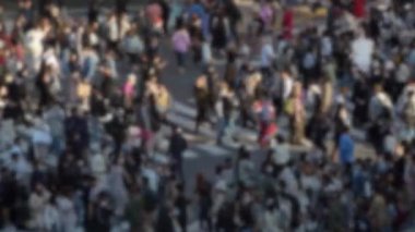 Shibuya Kavşağı 'nda yürüyen insanların yüksek görüşünün bulanık, odaklanmış, yavaş görüntüsü. Şehir sokaklarında nüfusun yoğunluğu çok fazla. Verimli yaya trafiği akışı.
