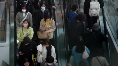 Tokyo, Japonya-10 Nisan 2023: Pek çok Asyalı alışverişçi alışveriş merkezinin yürüyen merdivenine biniyor, ve bunların arasında Japon tüketiciler de en hareketli zamanlarında alışveriş gezilerine çıkmak için hareket halindeki merdivenleri kullanıyorlar..