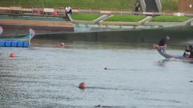 Taipei, Tayvan-08 Haziran 2024: Taipei ejderha botu takımının hareketsiz durarak yarışa başlaması, raketlerin ritm ve güçlü çabalarla hızlanmasıyla kıyıdan filme alınması.