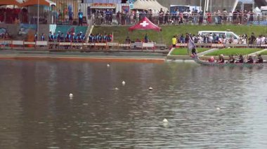 Taipei, Tayvan-08 Haziran 2024: Taipei ejderha botu yarışında kadın kürekçinin yavaş hareketi, güç, konsantrasyon ve güneş ışığının düşüşünü gösteren yakın çekim görüntüleri.