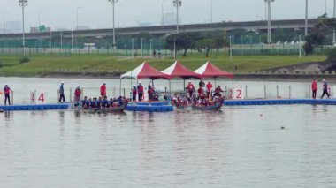 Taipei, Tayvan-08 Haziran 2024: Festivalde güneş ışığı yansımaları ve yoğun konsantrasyonla çerçevelenmiş, kıyıdan kürek çeken Taipei kürekçisinin yavaş hareketi.