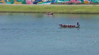 Taipei, Tayvan-08 Haziran 2024: Taipei kürekçisinin yavaş çekim kuvveti vücut, yan ışık ve göl yüzeyinde hafif dalgalanmalarla dinleniyor.