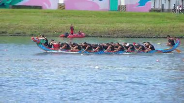 Taipei, Tayvan-08 Haziran 2024: Çırpınmaya hazırlanan Taipei kürekçisinin yavaş hareketi, yumuşak su parıltısı ve durgun hava ile yandan çekiliyor.