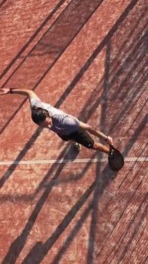 Dış sahada raket oynamayı öğrenen bir adamın dikey, üst görünümü. Topa vurmak için çeşitli Padel teknikleri kullanıyor..