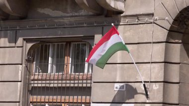 Macaristan bayrağının Budapeşte 'deki bir yerleşim yerinde dalgalanması, dingin bir ortamda vatanseverlik ve kentsel gururu simgeliyor..