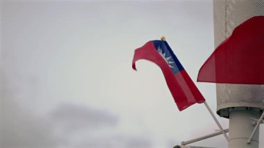 Tayvan bayrağının yavaşça hafif bulutlara doğru sallanması barış ve gururu temsil ediyor. Barışçıl ve kültürel temalar için uygun.