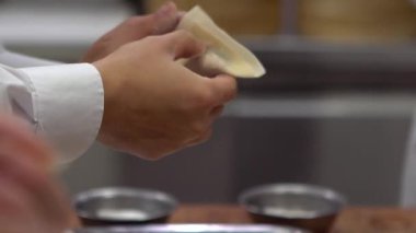 Tayvan şeflerinden oluşan bir takımın geleneksel yemekleri yavaş çekimde pişirmesi. Asyalı şef Tayvan restoranında taze börek yapıyor. Erkekler elleriyle hamur köftesi pişirir ve hazırlarlar..