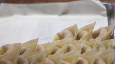 Tayvanlı şeflerden oluşan bir ekibin yavaş hareketi geleneksel hamur köftelerini ustalıkla hazırlıyor, elleri hamuru ustalıkla şekillendiriyor. Kalabalık bir restoranda şefler taze ve otantik tatlar yaratırlar..