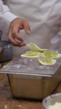 Tayvanlı şeflerden oluşan dikey bir ekip geleneksel yemekler pişiriyor. Asyalı şef Tayvan restoranında taze börek yapıyor. Erkekler elleriyle hamur köftesi pişirir ve hazırlarlar..