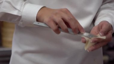 Tayvanlı şeflerden oluşan bir ekibin yavaş hareketi geleneksel hamur köftelerini ustalıkla hazırlıyor, elleri hamuru ustalıkla şekillendiriyor. Kalabalık bir restoranda şefler taze ve otantik tatlar yaratırlar..