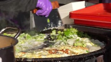 Taichung 'daki markette kağıt tabakta servis edilecek istiridye omletinin yavaş yavaş pişirilmesi.