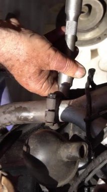 Dikey İkinci Mekanik, açık hava atölyesindeki klasik bir araba motorunu onarmak için işbirliği yapıyor. Takım çalışması ve detaylı mekanik çalışma.