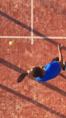 Açık havada tenis oynayan bir adamın dikey, üstten çekimi. Padel yarışmasına hazırlanıyor..