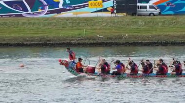 Taipei, Tayvan-08 Haziran 2024: Durgun suda kürek çeken Taipei kürekçisinin yavaş hareketi, göle hafifçe yansıyan sıcak güneş ışığı.