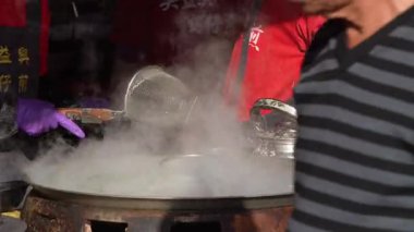 Taichung, Tayvan-13 Şubat 2024: Tayvan 'ın Tayvan kentinde geleneksel bir markette sıcak bir tabakta yavaş yavaş pişirilen istiridye omleti