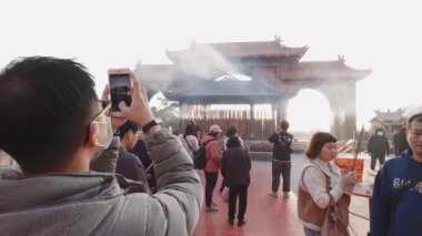 Taichung, Tayvan-29 Ocak 2025, Sanyang Longjing Tiangong Tapınağı 'nın önünde toplanan kalabalık. Sıcak ışık ve çevre dumanı barışçıl ruhsal atmosfer yaratır..