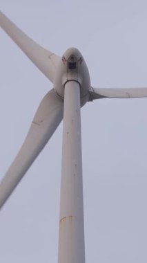 Taichung, Tayvan-21 Şubat 2025: Bulutlu gökyüzü altında dönen rüzgar türbininin dikey çerçevesi, yenilenebilir enerji çabalarını ve rüzgar kaynaklarının çevresel sürdürülebilirliğini simgeliyor.