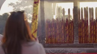 Taichung 'daki geleneksel bir tapınak ayini sırasında sessizce dua eden genç bir kadının tütsü yakma merasimiyle yüzleşmesi..