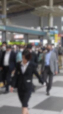 Gündüz vakti Tokyo yaya geçidinde yürüyen Asyalı yayaların dikey görüntüsü biraz dağılmış durumda. Rutin, hareketli ve ortak ritmi çağrıştırıyor..