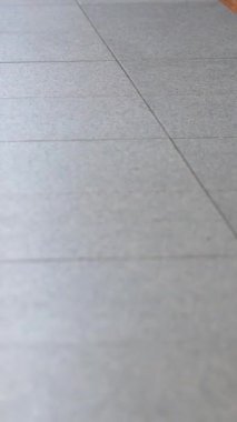  Tokyo 'da işe gidiş saatleri boyunca sert betonun üzerinde hızla yürüyen ayakların ayrıntılı dikey görüntüsü. Şehir stresi ve rutini hızlı tempolu alt çerçeve kompozisyonu ile kaydedildi.