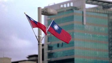Modern vatanseverliği ve ulusal gururu vurgulayarak, şehir zemininde dalgalanan Tayvan bayrakları yavaş hareket ediyor. Kültürel ve şehir manzarası görselleri için uygundur.
