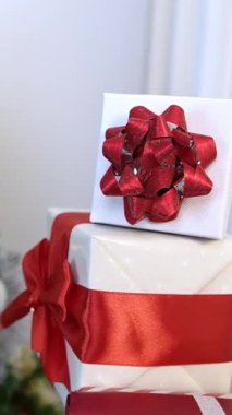 Çağdaş Noel ağacının altında, Noel süsleri ile tamamlanmış, beyaz bir arka planda duran dikey paketlenmiş hediye kutuları, yeni yıl için bir şenlik..