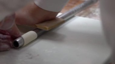 Tayvanlı bir aşçının yavaş çekimde hamuru çıkarıp içini Çin mantısı Jiaozi için baharatlı etle doldurmaya hazır hale getiriyor. Restoranın mutfağında hamur işi hazırlayan Asyalı bir adam.