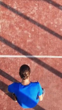 Raketle hayali çizgileri işaretleyen ve raket tenis okulundaki antrenman sırasında topa vuran bir Padel oyuncusunun dikey, üstten çekimi. Kürek tenisi öğrenme kavramı.