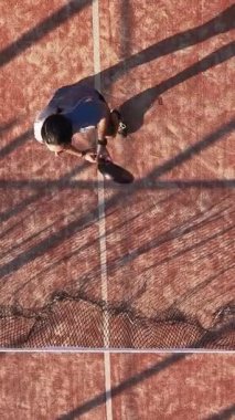 Dış sahada raket tenisi oynayan bir adamın dikey, üst görünümü. Padel oynamayı öğrenmek, bir kulüpte ders almak..
