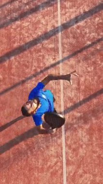 Açık hava sahasında maç yapan profesyonel bir raket tenisçisinin dikey ve tepeden çekimi..