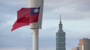 Taipei, Tayvan-14 Ekim 2024: Tayvan bayrağının rüzgarda dalgalanması ve Tayvan 101 'in yakınındaki bulutlu gökyüzü manzaralı bir şehirde milli gururu yakalaması.