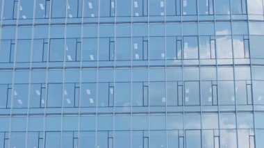 Güney Kore 'nin orta kesiminde, mavi tonlu ve geometrik desenli modern bir iş bölgesinde bulutları yansıtan cam ön cephe yavaş hareket ediyor.
