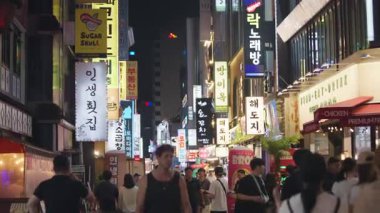 Güney Kore, Seul - 08 Temmuz 2025: Jonggak, Seul 'deki aydınlık gece caddesinde yürüyen yavaş insanlar, renkli neon levhalarla çevrili, yerel halk ve turistlerle canlı bir atmosfer yaratıyorlar.