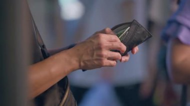 Güney Kore, Seul - 08 Temmuz 2025: Myeongdong gece pazarındaki müşterilerden para alan Koreli sokak satıcıları, yiyecek tezgahlarının yanında sıcak ışık altında para alışverişinde bulunuyor.