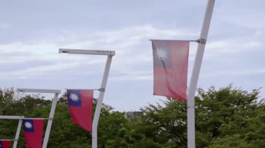 Bulutlu bir gökyüzünün altında dalgalanan Tayvan bayrakları, değişen havanın ortasında ulusal gururu vurguluyor..