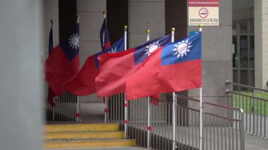 Taipei, Tayvan-15 Ekim 2024: Modern bir binanın yanında dalgalanan Tayvan bayrağı, ulusal gururu kentsel estetikle harmanlıyor.