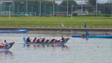 Taipei, Tayvan-08 Haziran 2024: Geleneksel kıyafetli Taipei kürekçisinin güneşin altında festival etkinliği sırasında yan taraftan çekilen kürek çekme hareketi.