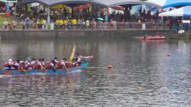 Taipei, Tayvan-08 Haziran 2024: Taipei 'deki ejderha teknesi yarışı sırasında ağır çekimde ağır kürek çeken bir adam görülüyor..