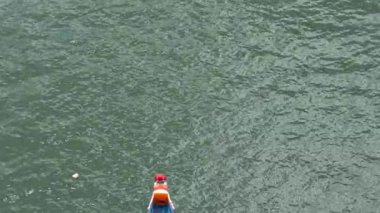 Taipei, Tayvan-08 Haziran 2024: Taipei raketlerinin ağır çekim gücü, vücudu ayarlıyor, suda dans eden yansımalarla dizlerinin üzerinde kürek çekiyor.