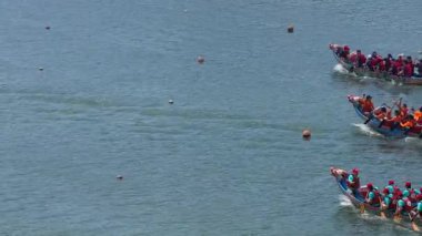 Taipei, Tayvan-08 Haziran 2024: Irklar arasında dinlenen Taipei ejderha kayıkçılarının yavaş hareketi, kıyıdan su dalgaları ve arka plandaki ağaçların yansıması ile sakince yakalandı.