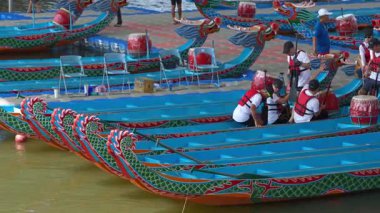 Taipei, Tayvan-08 Haziran 2024: Taipei kürekçisinin yavaşça kollarını uzatması, yanında kürek çekmesi, gölde altın saat parlaması.