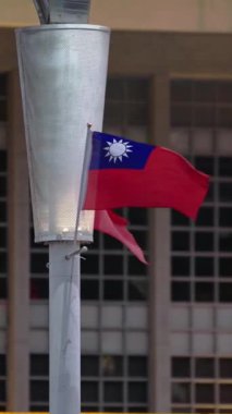 Modern vatanseverliği ve ulusal gururu vurgulayarak, şehir zemininde dalgalanan Tayvan bayraklarının dikey yavaş hareketi. Kültürel ve şehir manzarası görselleri için uygundur.