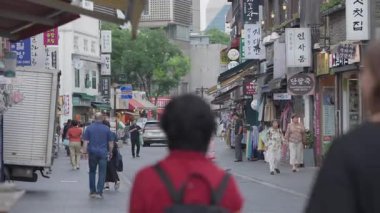Seul, Güney Kore-08 Temmuz 2025: İnsadong kültürel caddesinde yürüyen yayalar, bulutlu bir öğleden sonra dükkanlar, tabelalar ve turist ve yerli halkla çevrili.