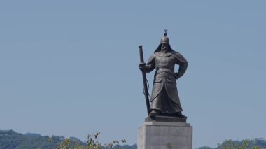 Güney Kore, Seul - 10 Temmuz 2025: Gwanghwamun, Seul 'da berrak bir gökyüzünün altında duran Amiral Yi Sun-sin heykeli yavaş çekim görüntüsü