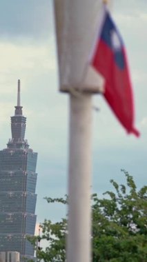 Taipei, Tayvan-14 Ekim 2024: Tayvan bayrağının dalgalanışının dikey yavaş çekimi, Tayvan kimliği ve mimari mucizesini vurguluyor..