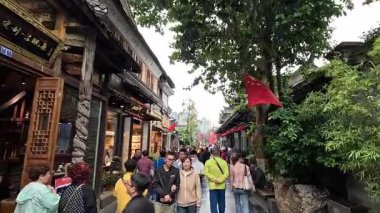 Chengdu, Çin-11 Ekim 2024: Chengdu 'da fenerlerle ve sokak faaliyetleriyle dolu eski tarz Çin binalarının önünden geçen ziyaretçiler