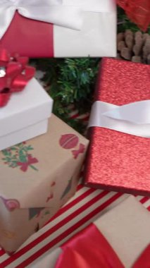 Modern bir Noel ağacının altında dikey olarak, zarif bir şekilde paketlenmiş hediye kutuları Noel süsleri, yeni yıl dekorasyonu için tasarım unsurları ve beyaz arka planlı bir evde tatil atmosferini arttırır..