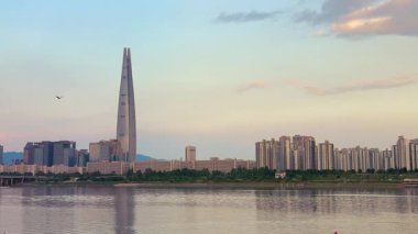 Seul, Güney Kore-09 Temmuz 2025: Lotte Dünya Kulesi ve Güney Kore 'de altın saat boyunca sıcak yaz ışığı ve berrak gökyüzü ile çevreleyen gökyüzü