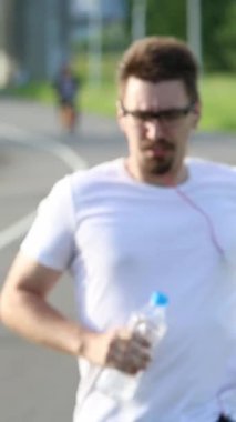 Tayvan 'da Teh Parkı yolunda koştuktan sonra su içen beyaz bir adam. Egzersiz Konsepti. Spor yaşam tarzı.